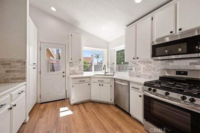 1288 Capitola St, Grover Beach, CA 93433 - kitchen with appliances with stainless steel finishes, vaulted ceiling, tasteful backsplash, white cabinets, and recessed lighting