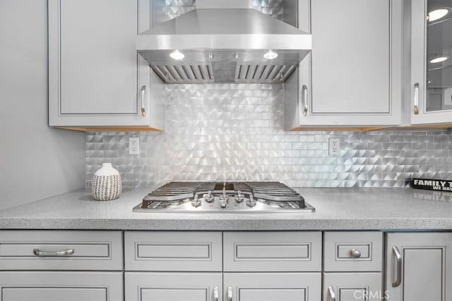 28639 Quaint St, Agoura Hills, CA 91301 - kitchen featuring wall chimney exhaust hood, stainless steel gas cooktop, glass insert cabinets, backsplash, and light stone countertops