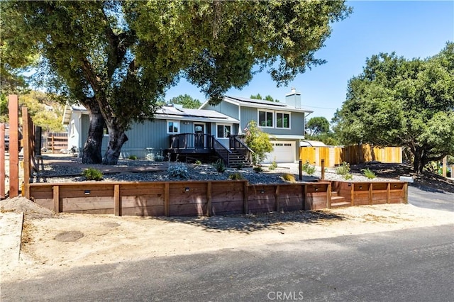 4725 Arena Ave, Atascadero, CA 93422 - tri-level home featuring roof mounted solar panels, a chimney, stairway, and a wooden deck