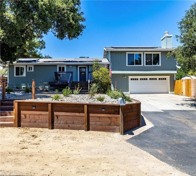 4725 Arena Ave, Atascadero, CA 93422 - view of front of property with roof mounted solar panels, a chimney, a garage, a deck, and driveway
