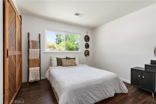 4725 Arena Ave, Atascadero, CA 93422 - bedroom featuring a barn door and dark wood-style flooring