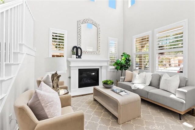 27 Cache St, Rancho Mission Viejo, CA 92694 - living area with a high ceiling, wood finished floors, and a glass covered fireplace