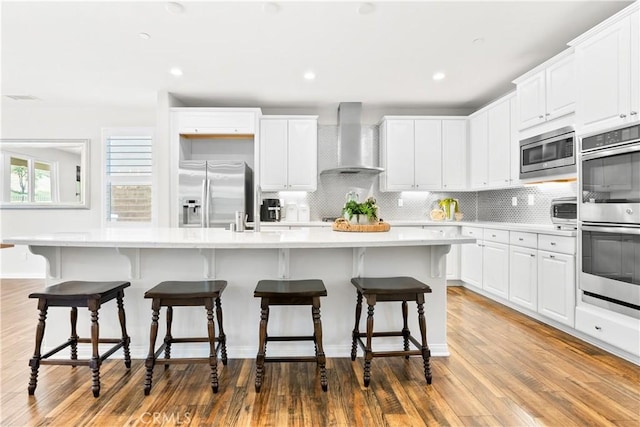 27 Cache St, Rancho Mission Viejo, CA 92694 - kitchen featuring wall chimney range hood, stainless steel appliances, white cabinets, decorative backsplash, and recessed lighting