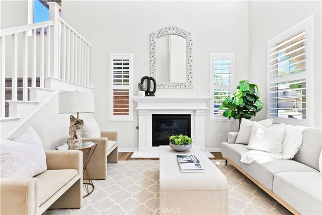 27 Cache St, Rancho Mission Viejo, CA 92694 - living room featuring wood finished floors, a towering ceiling, and a glass covered fireplace