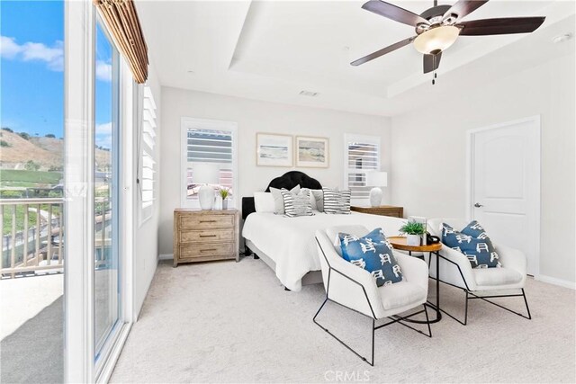 27 Cache St, Rancho Mission Viejo, CA 92694 - bedroom featuring a tray ceiling, light carpet, multiple windows, and a ceiling fan