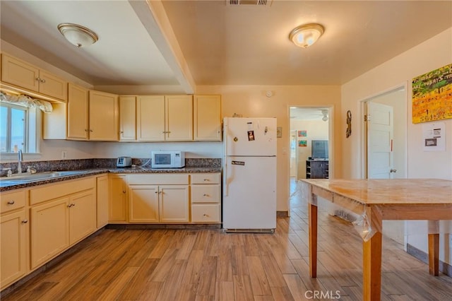 9668 W Rosamond Blvd, Rosamond, CA 93560 - kitchen with white appliances, light wood-style floors, dark countertops, and cream cabinets