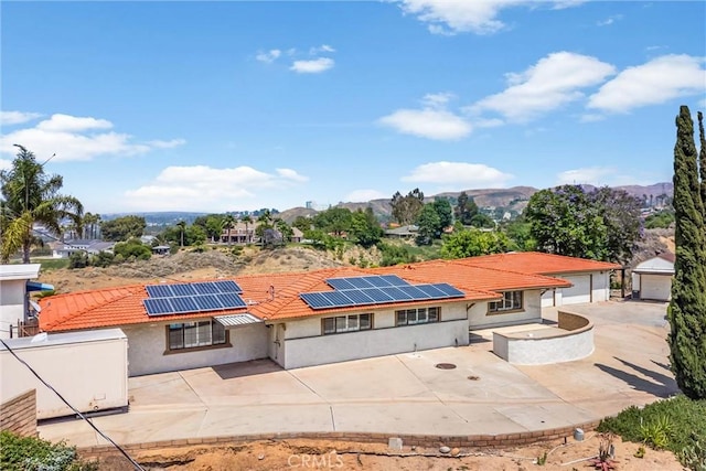 1835 Hilltop Dr, Colton, CA 92324 - rear view of house featuring a patio area, stucco siding, solar panels, a tiled roof, and a mountain view