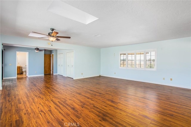1835 Hilltop Dr, Colton, CA 92324 - empty room featuring a skylight, a ceiling fan, dark wood finished floors, and a textured ceiling