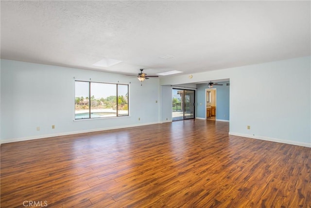 1835 Hilltop Dr, Colton, CA 92324 - empty room featuring a skylight, dark wood-style flooring, a ceiling fan, and a textured ceiling