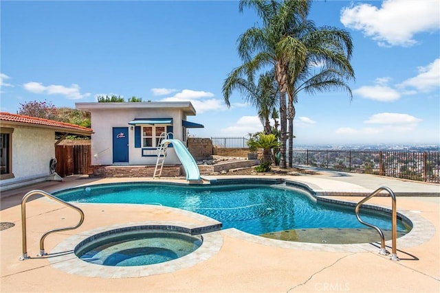 1835 Hilltop Dr, Colton, CA 92324 - view of swimming pool with a water slide, an in-ground hot tub, an outbuilding, a patio area, and a fenced backyard