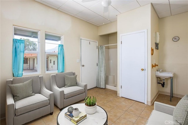 1835 Hilltop Dr, Colton, CA 92324 - living room with a drop ceiling, light tile patterned flooring, and a ceiling fan