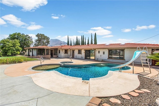 1835 Hilltop Dr, Colton, CA 92324 - view of swimming pool featuring a water slide, a patio area, a mountain view, and a pool with connected hot tub