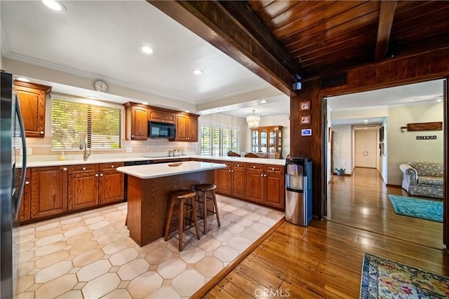 416 N Westridge Ave, Glendora, CA 91741 - kitchen featuring black appliances, a kitchen breakfast bar, a kitchen island, light countertops, and brown cabinets