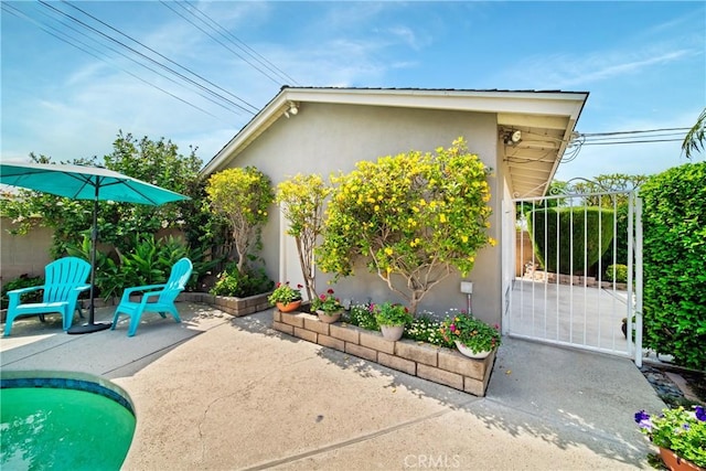 416 N Westridge Ave, Glendora, CA 91741 - view of property exterior featuring stucco siding, a patio area, and a gate
