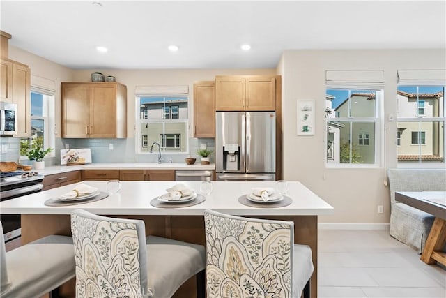 780 Stirrup, Rancho Mission Viejo, CA 92694 - kitchen featuring stainless steel appliances, a breakfast bar, light countertops, light brown cabinets, and recessed lighting