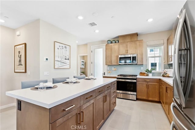 780 Stirrup, Rancho Mission Viejo, CA 92694 - kitchen featuring appliances with stainless steel finishes, a center island, light countertops, decorative backsplash, and recessed lighting