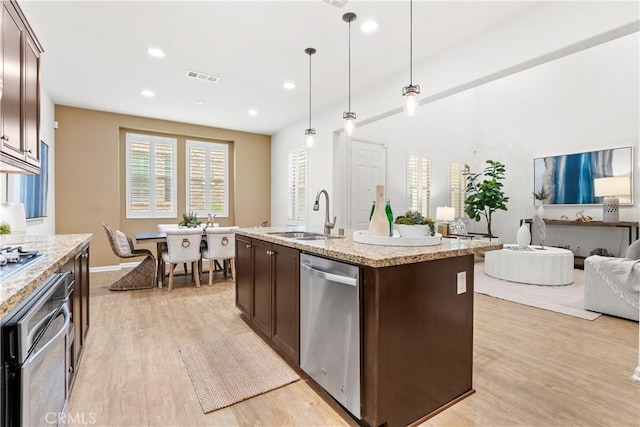 152 Jaripol Cir, Rancho Mission Viejo, CA 92694 - kitchen featuring appliances with stainless steel finishes, dark brown cabinetry, light wood finished floors, open floor plan, and hanging light fixtures