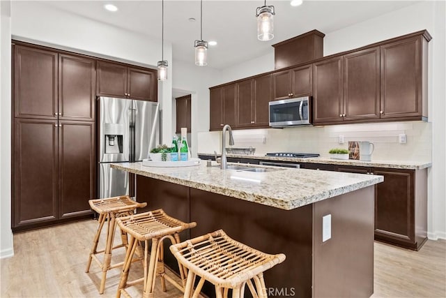 152 Jaripol Cir, Rancho Mission Viejo, CA 92694 - kitchen with appliances with stainless steel finishes, dark brown cabinetry, light wood-type flooring, tasteful backsplash, and recessed lighting