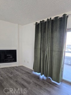 9633 Juniper Ave Unit F2, Fontana, CA 92335 - unfurnished living room featuring wood finished floors, a textured ceiling, and a fireplace