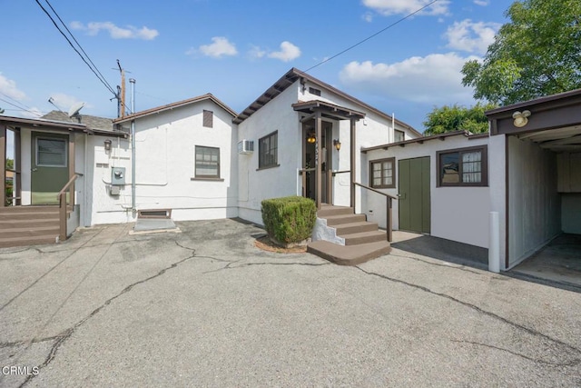 1430 Pepper Dr, Pasadena, CA 91104 - view of front of home with an outdoor structure, stucco siding, a patio, and an AC wall unit