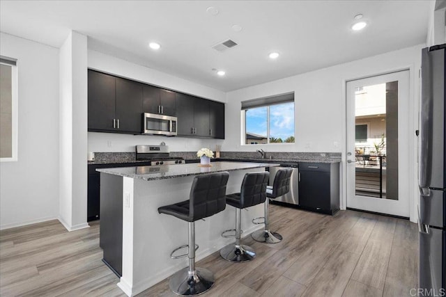 5265 Beachfront Cove St Unit 167, San Diego, CA 92154 - kitchen featuring stainless steel appliances, a breakfast bar area, light wood-type flooring, a kitchen island, and recessed lighting