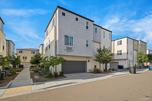 5265 Beachfront Cove St Unit 167, San Diego, CA 92154 - view of property with an attached garage, concrete driveway, and a residential view