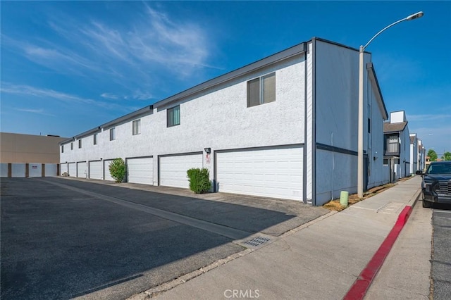 20821 E Calora St Unit E1, Covina, CA 91724 - view of home's exterior featuring asphalt driveway and stucco siding