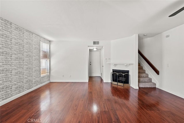 20821 E Calora St Unit E1, Covina, CA 91724 - unfurnished living room with brick wall, a fireplace, wood finished floors, ceiling fan, and stairs