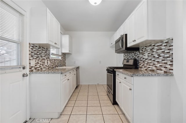 3604 Cortez St, Riverside, CA 92504 - kitchen featuring appliances with stainless steel finishes, backsplash, and white cabinetry