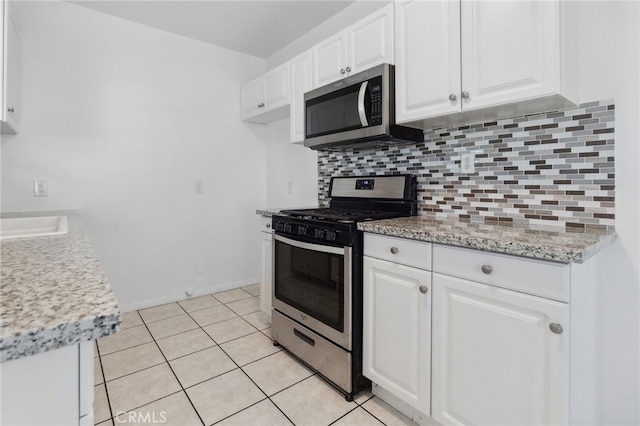 3604 Cortez St, Riverside, CA 92504 - kitchen featuring appliances with stainless steel finishes, white cabinets, decorative backsplash, and light tile patterned floors