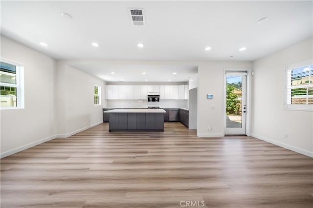 1379 Point Loma Pl, Walnut, CA 91789 - kitchen with light wood-style floors, white cabinets, plenty of natural light, a kitchen island, and recessed lighting