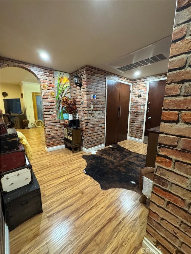 531 N Rossmore Ave Unit 202, Los Angeles, CA 90004 - foyer featuring arched walkways, wood finished floors, and brick wall