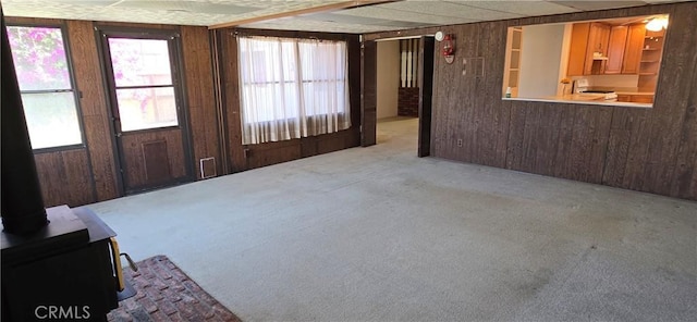 509 N 3rd St, Lompoc, CA 93436 - carpeted spare room featuring wood walls and a wood stove