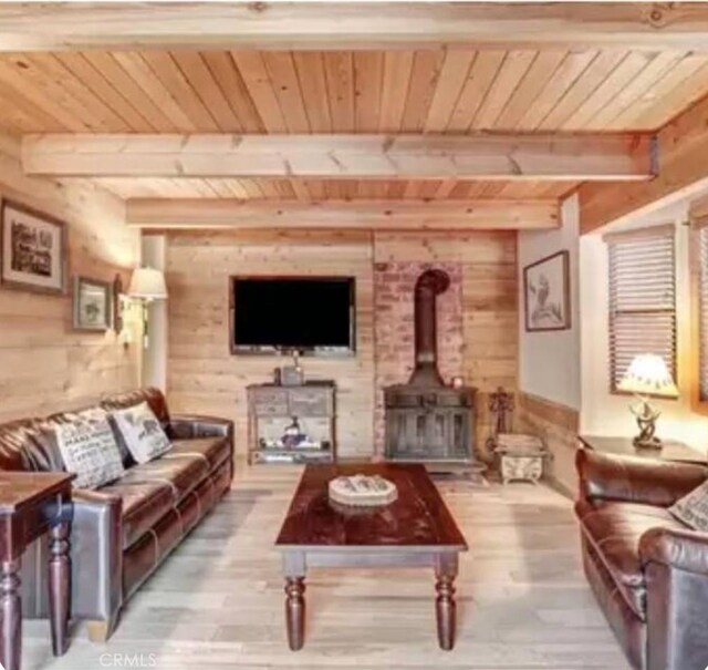 605 Kean Way, Big Bear City, CA 92314 - living area with a wood ceiling with exposed beams, wood finished floors, wooden walls, and a wood stove