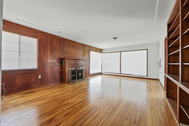 8802 Tyler St, Spring Valley, CA 91977 - unfurnished living room with a fireplace, light wood-style floors, and wooden walls