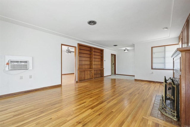 8802 Tyler St, Spring Valley, CA 91977 - unfurnished living room with an AC wall unit, a brick fireplace, and light wood-style floors