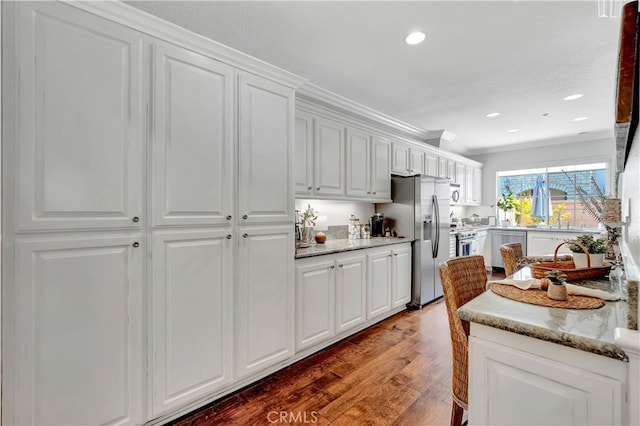 6 Camino Celeste, San Clemente, CA 92673 - kitchen with appliances with stainless steel finishes, wood finished floors, crown molding, white cabinets, and light stone counters