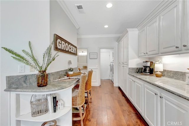 6 Camino Celeste, San Clemente, CA 92673 - kitchen featuring crown molding, white cabinetry, washer / clothes dryer, hardwood / wood-style floors, and recessed lighting