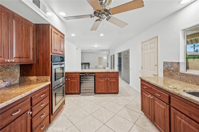 75406 Montecito Dr, Indian Wells, CA 92210 - kitchen featuring wine cooler, double oven, decorative backsplash, a peninsula, and light tile patterned flooring