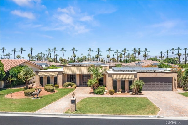 75406 Montecito Dr, Indian Wells, CA 92210 - view of front of house with an attached garage, driveway, a front yard, solar panels, and stucco siding