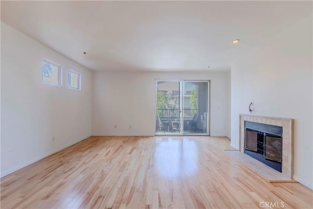 4568 W 1st St Unit 203, Los Angeles, CA 90004 - unfurnished living room featuring light wood-type flooring, a tiled fireplace, and recessed lighting