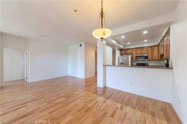 4568 W 1st St Unit 203, Los Angeles, CA 90004 - kitchen with appliances with stainless steel finishes, brown cabinets, light wood-style flooring, hanging light fixtures, and recessed lighting