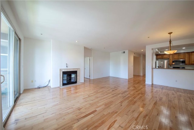 4568 W 1st St Unit 203, Los Angeles, CA 90004 - unfurnished living room with light wood-style flooring, recessed lighting, and a fireplace with flush hearth