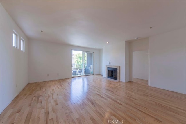 4568 W 1st St Unit 203, Los Angeles, CA 90004 - unfurnished living room featuring light wood-style floors and a tiled fireplace