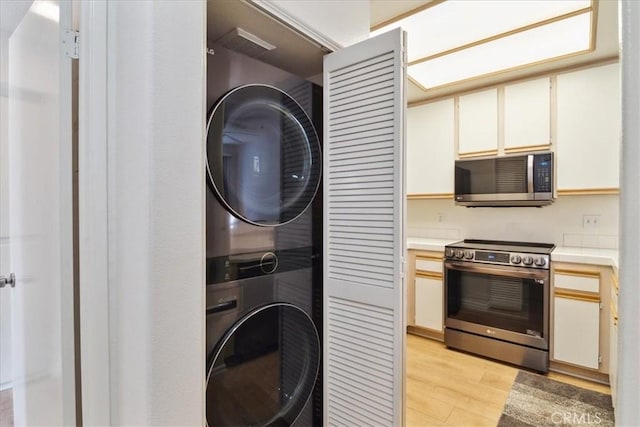 2960 Champion Way Unit 1006, Tustin, CA 92782 - laundry area featuring stacked washer / drying machine and light wood-style floors