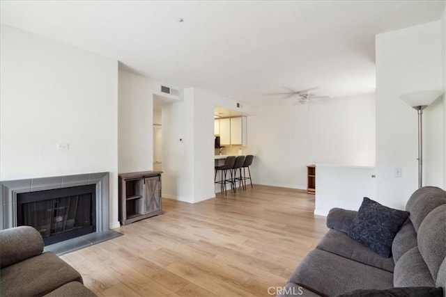 2960 Champion Way Unit 1006, Tustin, CA 92782 - living room featuring light wood-type flooring, ceiling fan, and a fireplace