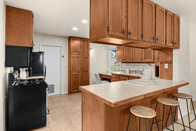 5530 Heidi St, La Mesa, CA 91942 - kitchen featuring black appliances, a peninsula, tile counters, backsplash, and brown cabinetry