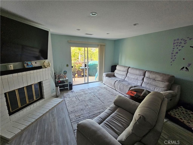 24377 Larchmont Ct Unit 32, Laguna Hills, CA 92653 - living area with a fireplace, a textured ceiling, wood finished floors, and recessed lighting