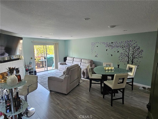 24377 Larchmont Ct Unit 32, Laguna Hills, CA 92653 - living area featuring dark wood finished floors, a textured ceiling, and a brick fireplace