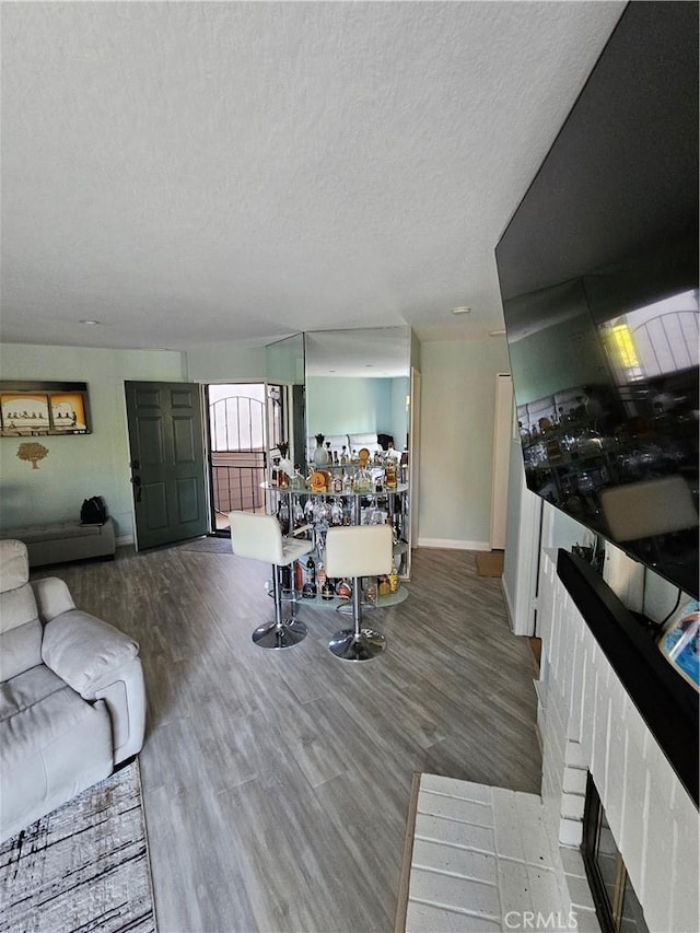 24377 Larchmont Ct Unit 32, Laguna Hills, CA 92653 - living area with a textured ceiling, wood finished floors, and a fireplace